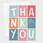 A colorful "thank you" card with a grid design featuring pastel blocks, each containing one letter with prayer hands, placed on a wooden surface.