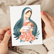 Illustration of Mary in a blue and cream headscarf tenderly holding a baby, with pink roses at the bottom. they are depicted on a white card