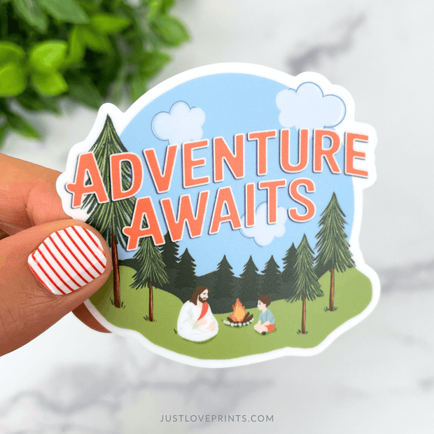 Sticker showing Jesus sitting by a campfire with children among pine trees, with the words “Adventure Awaits.”