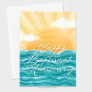 This image displays a beautifully designed card with the message "Happy Baptismal Anniversary" in elegant, flowing white script. The background showcases a bright, stylized sun rising over calm blue waves, creating a warm, inviting atmosphere. The soft yellow hues of the sun blend seamlessly with fluffy clouds, adding a serene and celebratory tone, ideal for commemorating this special anniversary.