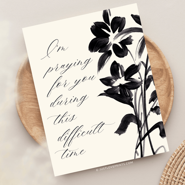 cream background with black painted flowers. I'm praying for you during this difficult time. 