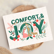 This charming holiday card design centers on the message "Comfort & Joy" in bold green lettering, adorned with festive elements. Nestled within the "O" is a serene nativity scene featuring Mary, Joseph, and Baby Jesus, symbolizing the peace and love of Christmas. Surrounding the text and scene are beautifully illustrated poinsettias, holly, pine sprigs, and small red berries, creating a harmonious and joyful holiday motif. 