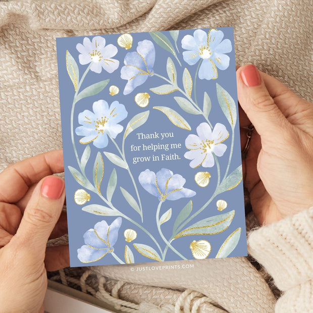 This card design features a heartfelt message, "Thank you for helping me grow in Faith," centered among delicate watercolor-style flowers. The background is a soft, muted blue, complementing the gentle tones of light blue and white flowers, which are accented with golden highlights on the petals and leaves. The botanical elements create a sense of grace and gratitude, making this design ideal for expressing appreciation with a spiritual touch.