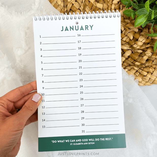 Hand holding a January calendar with a quote on a light background