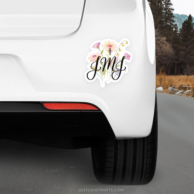 Floral background with letters JMJ and cross on a car
