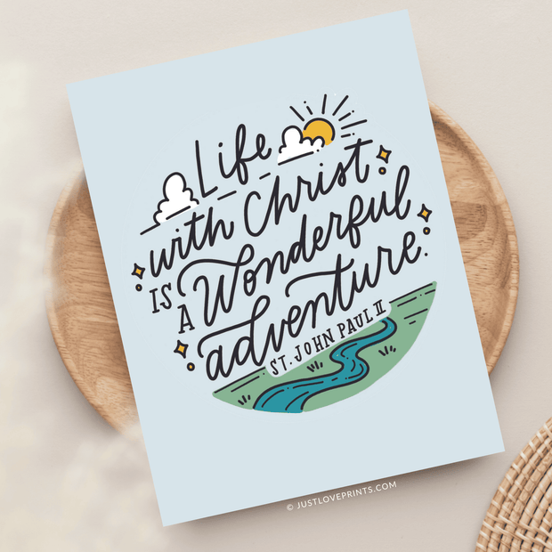 Greeting card with a quote "life with christ is a wonderful adventure." attributed to st. john paul ii, featuring playful illustrations of a sun, clouds, and a river