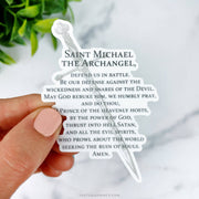 This sticker features the full St. Michael prayer, shaped around a silver sword graphic, adding a symbol of strength and protection to the text.