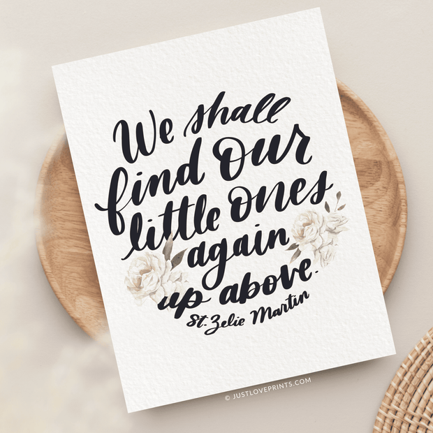 A decorative card featuring a handwritten quote, "we shall find our little ones again up above. -st. zelie martin," adorned with floral graphics