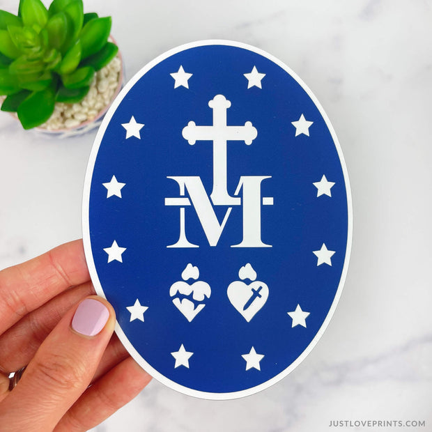 Blue M with Cross, two Holy Family hearts, with 12 stars. 